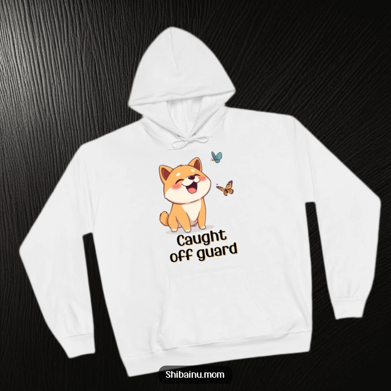 Funny hoodie showing a surprised Shiba Inu dog giggling at a falling butterfly, offering warmth and a dose of whimsical humor.
